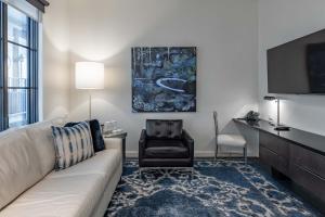 a living room with a couch and a chair at 121 Hotel by AvantStay Chic Modern Hotel In Nashville in Nashville