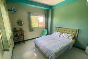 a bedroom with a bed and a window at The Green House in Sorsogon