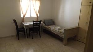 ein kleines Zimmer mit einem Bett, einem Tisch und Stühlen in der Unterkunft Dum u lesa in Biriyya