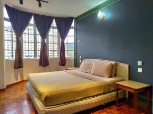 a bedroom with a large bed with blue walls and windows at The Little Star Hotel & Studio at Star Regency Residence in Brinchang