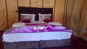 una camera con un grande letto in una tenda di camp erg znaigui a Taouz