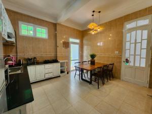a kitchen with a table and chairs in a room at SAKURA VILLA - Venuestay in Da Thien