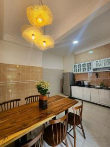 a large kitchen with a wooden table and chairs at SAKURA VILLA - Venuestay in Da Thien