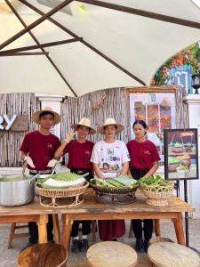 a group of people standing around a table with food at Youth's Dream Fulfillment Association in Siem Reap