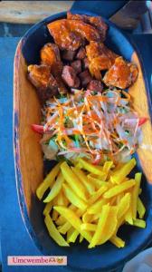 un plato azul de comida con ensalada y papas fritas en Run n Fire en Mbabane
