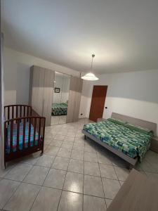 a bedroom with a bed and a crib in it at Casa Sophie in Oristano