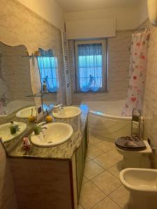 a bathroom with two sinks and a tub and a toilet at Casa Sophie in Oristano