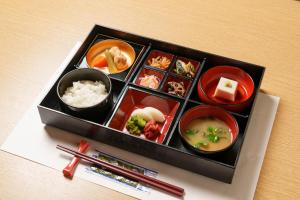 - un plateau de nourriture avec différents types d'aliments et des baguettes dans l'établissement Waqoo Shitaderamachi, à Osaka