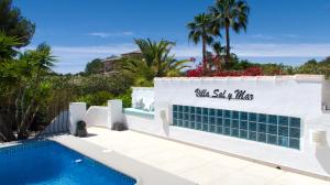 a villa with a swimming pool and palm trees at Villa Sal y Mar - Jávea ! Freshly Renovated ! in Jávea