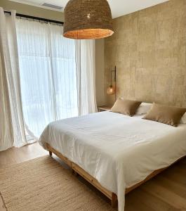 - une chambre avec un grand lit et une grande fenêtre dans l'établissement Villa Sophie, à Lanton