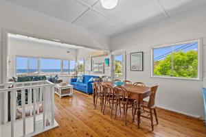 a dining room and living room with a table and chairs at Delightful 3-Bed Home Minutes from Avoca Beach in Avoca Beach