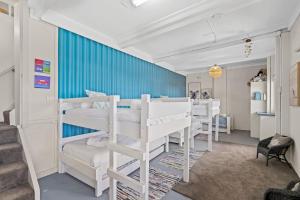 a bedroom with four bunk beds and a blue wall at Delightful 3-Bed Home Minutes from Avoca Beach in Avoca Beach