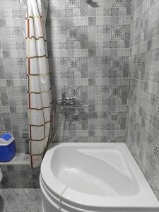 a bathroom with a white toilet and a tub at NIYAT HOTEL in Urganch