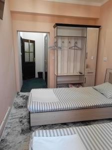 1 dormitorio con 2 camas y armario en NIYAT HOTEL, en Urganch