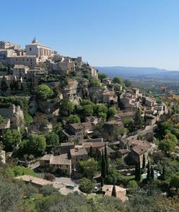 a village on a hill with houses at MES NUITS VINTAGE EN COMBI in Robion en Luberon