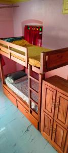 a wooden bunk bed with a wooden cabinet at Hostel Gandhi Thiruvananthapuram in Trivandrum