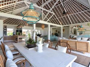 a dining room with a white table and chairs at Driftwood Villas Lembongan in Nusa Lembongan