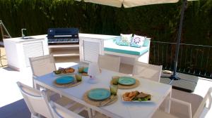 una mesa blanca con platos de comida. en Villa Sal y Mar - Jávea ! Freshly Renovated ! en Jávea