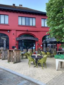 a red building with tables and chairs in front of it at Gîte d'Avalon Appartement 5 in Dinant
