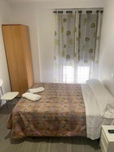 1 dormitorio con 1 cama con 2 toallas en La Ferroviaria - Habitaciones Con Baño Privado y Compartido - Sin Ascensor, en Zaragoza