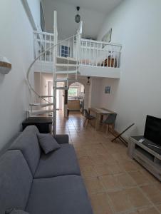 sala de estar con sofá y escalera en Charmant appartement avec jardin au calme en Châteauneuf