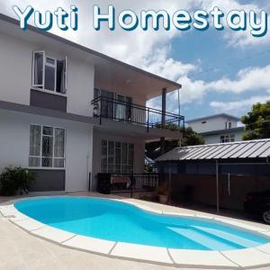 uma casa com uma piscina em frente em Yuti Homestay em Quatre Bornes