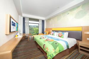 Cette chambre comprend un lit et un bureau. dans l'établissement Holiday Inn Express Emei Mountain, an IHG Hotel, à Emei Shan
