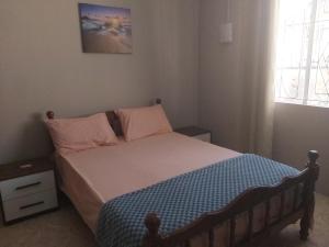 um pequeno quarto com uma cama com lençóis rosa e azul em Yuti Homestay em Quatre Bornes