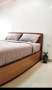 1 cama con marco de madera en un dormitorio en 66 Apartment en Ban Khlong Nong Yai