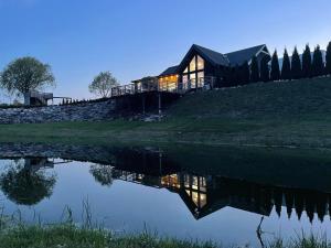 una casa sentada en la cima de una colina junto a un lago en Dwa Słowa, en Giżycko