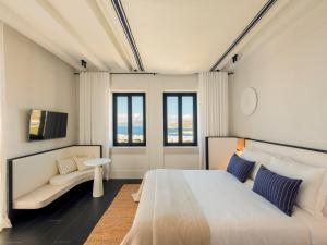 a bedroom with a large bed and a couch at Anandes Hotel in Mýkonos City