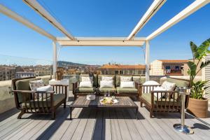 een terras met stoelen en een tafel bij Kronos on the Beach Attic Suite in Barcelona