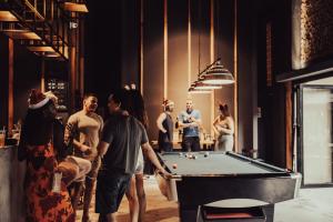 a group of people standing around a pool table at 9Station Hostel & Bar Phu Quoc in Phu Quoc