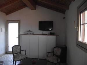 Casa Marcella Cugnana-Portisco في كوغنانا: غرفة معيشة مع كرسيين وتلفزيون