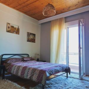 a bedroom with a bed and a large window at Skiff_View in Kastoria