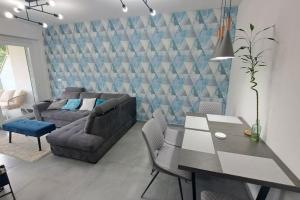 a living room with a table and a couch at Dél-Balaton Szíve Apartman in Balatonföldvár