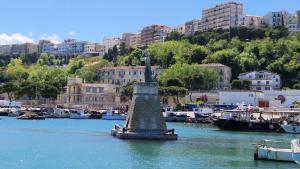 Une statue dans l'eau dans un port avec des bateaux dans l'établissement l'Apostolo e il Navarca, à Ortona