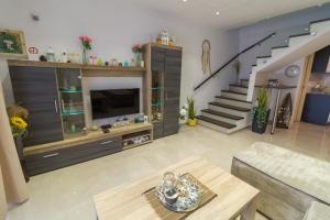 a living room with a tv and a staircase at Apartmani Vesić in Tivat