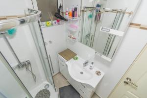 a white bathroom with a sink and a shower at Apartmani Vesić in Tivat