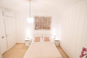 1 dormitorio blanco con 1 cama y 2 mesitas de noche en AirPort NOA Modern Home en Fiumicino