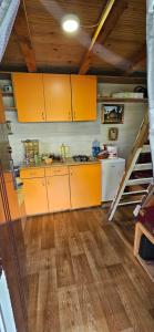 a kitchen with yellow cabinets and a staircase at Hogar Splav Perucac in Perućac
