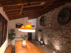 um quarto com uma mesa com um candeeiro e uma parede de pedra em El currillo preciosa casa rural al lado cabarceno em Argomilla