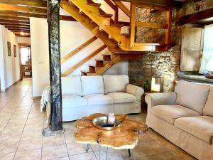 uma sala de estar com um sofá e uma mesa de centro em El currillo preciosa casa rural al lado cabarceno em Argomilla