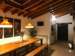 a dining room with a wooden table and two lights at El currillo preciosa casa rural al lado cabarceno in Argomilla