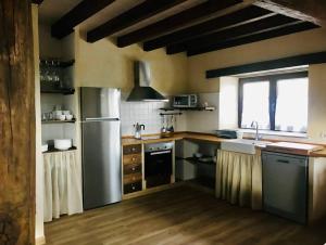 uma cozinha com um frigorífico de aço inoxidável e uma janela em La Fontana descubre Cabarceno y Cantabria em Villacarriedo