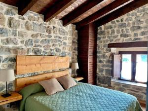 Un dormitorio con una cama en una pared de piedra. en La Fontana de Pedroso, descubre Cabárceno y Cantabria, en Villacarriedo