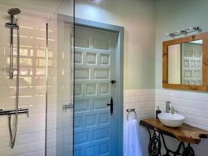 uma casa de banho com uma porta azul e um lavatório em La Fontana descubre Cabarceno y Cantabria em Villacarriedo