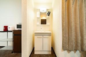 a small kitchen with a sink and a microwave at 84-5, Shiomi 301, Entire room for rent in Tokyo