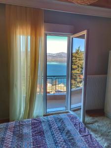 a bedroom with a bed and a view of the ocean at Skiff_View in Kastoria