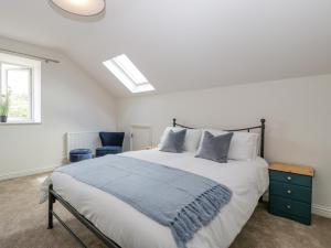 a bedroom with a large bed and a window at Threshing Barn in Blandford Forum